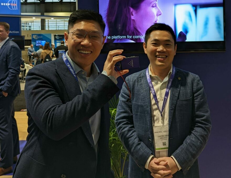 harrison.ai, Annalise.ai & Franklin.ai co-founders Dr Aengus Tran & Dimitry Tran at RSNA 2022. Aengus holds an AI-on-a-chip device for offline use, pre-loaded with Annalise.ai diagnostic capabilities.